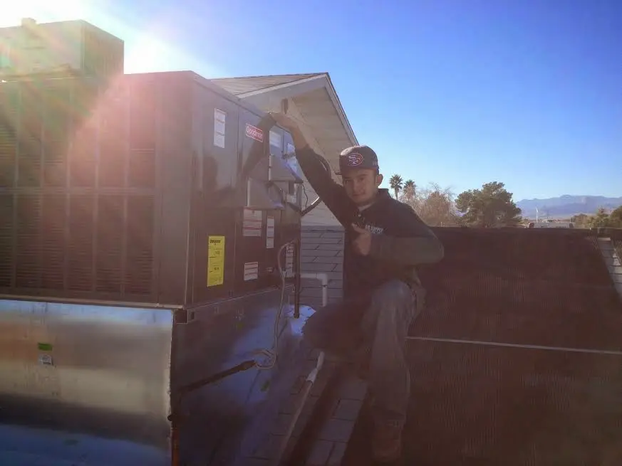 HVAC technician performing Boiler Repair on a rooftop unit in Warwick